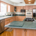 Well-maintained mid-century modern kitchen featuring wood cabinets and an island in a Southfield home with Birmingham school
