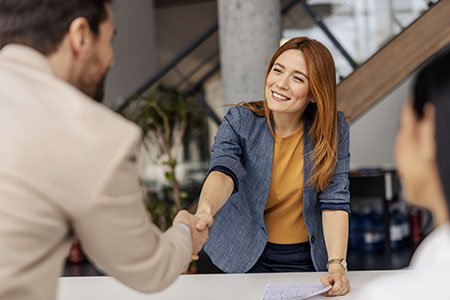 Portrait Of Friendly Female Shaking Hands With New Client
