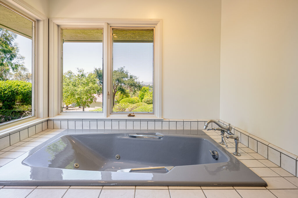Secondary bedroom with large window, natural light, and dresser at 145 Yucca Rd Fallbrook
