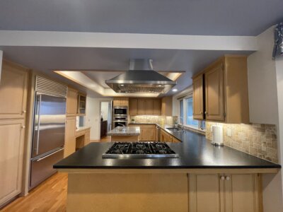 Kitchen and dining area during rainy day Fallbrook open house at 145 Yucca Road with windows looking out to trees.