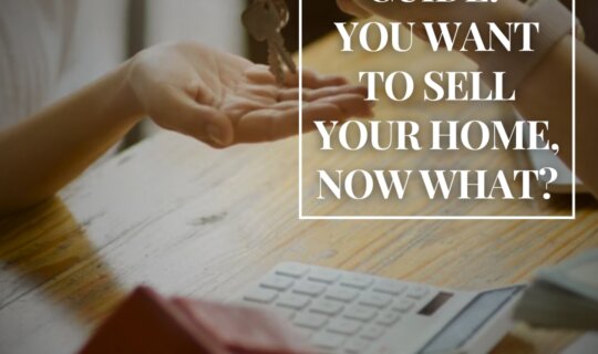 Home seller guide concept -- real estate agent handing over house keys with calculator and paperwork on table.